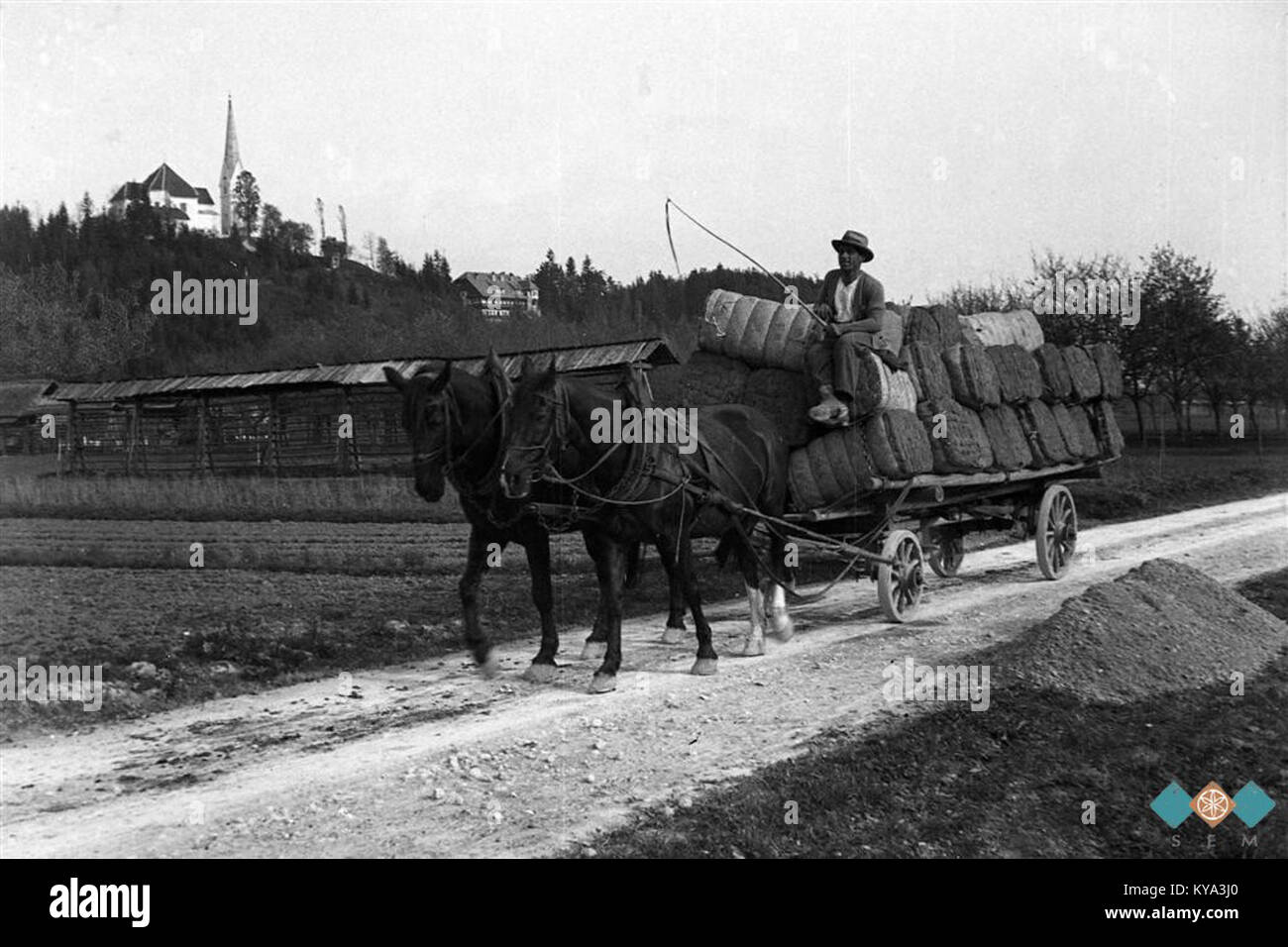 Una scena del 1933 in Slovenia mostra un carrello che trasporta reti da pesca e materiali per la fabbricazione delle scope passando da Homca a Naglicev House, illustrando la vita rurale e le pratiche commerciali. Foto Stock