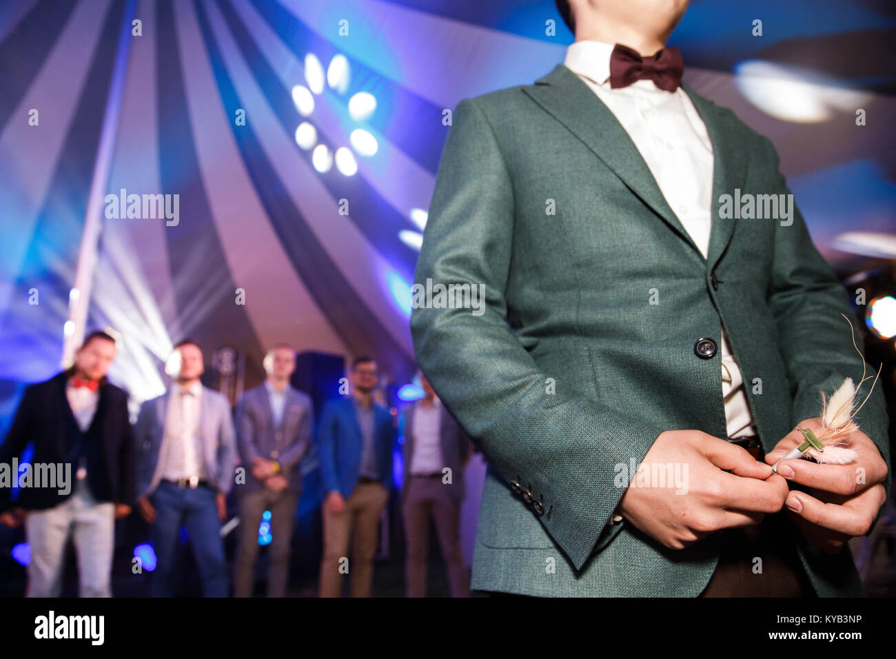 Boutonniere nelle mani dello sposo al banchetto. Foto Stock
