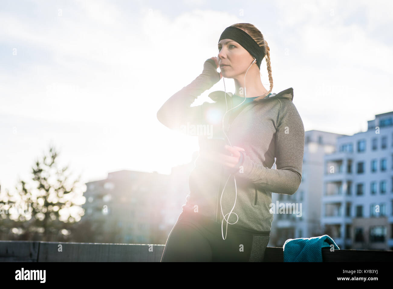 Giovane donna pronto per l'allenamento all'aperto ascoltando la musica tramite Foto Stock