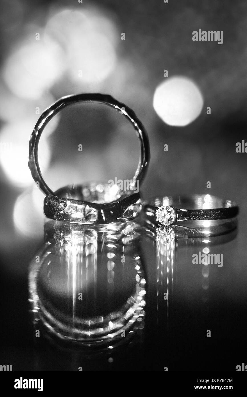 Tre anelli di nozze sulla superficie riflettente con evidenza. Foto Stock