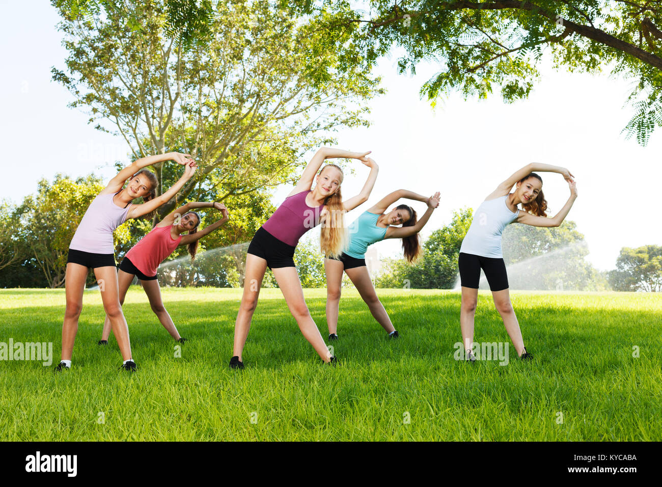 Il gruppo di cinque ragazze felici di fare esercizi di flessibilità Foto Stock