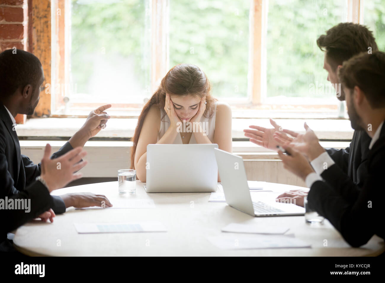 Colleghi di sesso maschile dita di puntamento a sconvolgere il boss femmina sulla riunione, stanchi triste donna leader sperimentando la discriminazione tra uomini e donne sul posto di lavoro, imprenditori blami Foto Stock