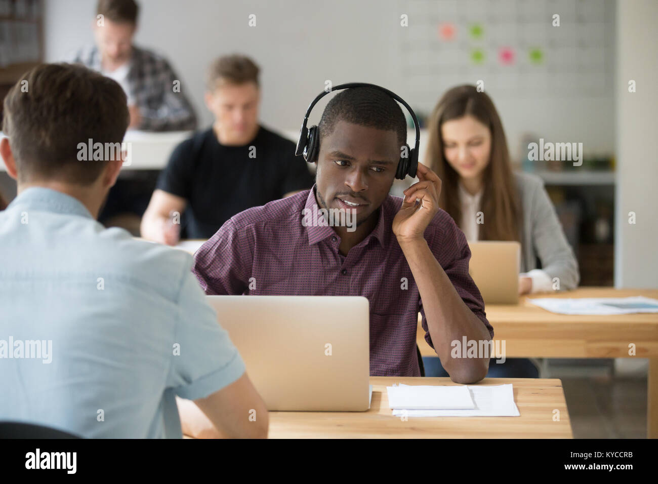 African American sales manager di indossare un auricolare wireless client di consulenza a sostegno co-working scrivania da ufficio, nero agente del call center cuffie in tal Foto Stock