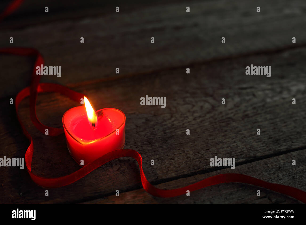 A forma di cuore la masterizzazione di candela su sfondo di legno, il giorno di San Valentino concetto Foto Stock