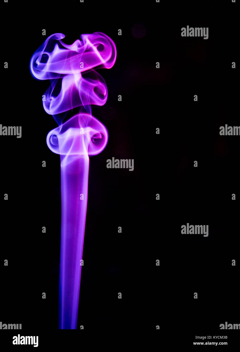 Un isolato la colonna verticale di fumo colorato che mostra in rosso e riflessi violacei avente sia scientifico e fascino artistico come pure la copia in bianco e nero di spazio Foto Stock