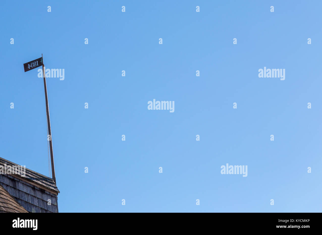 Datata placca su una lunga asta bloccata su un tetto Foto Stock