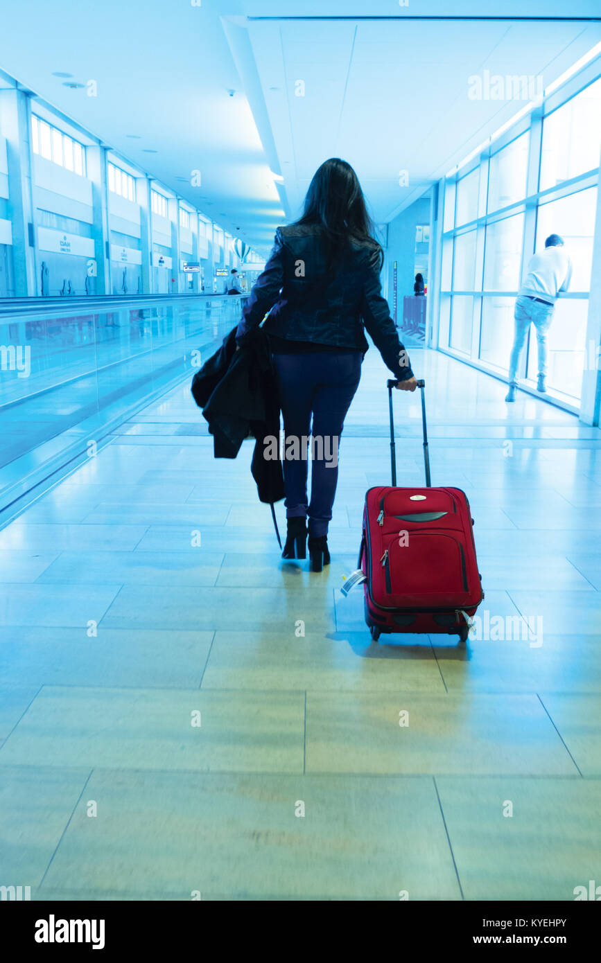 La ragazza con la valigia è a piedi in aeroporto Foto Stock