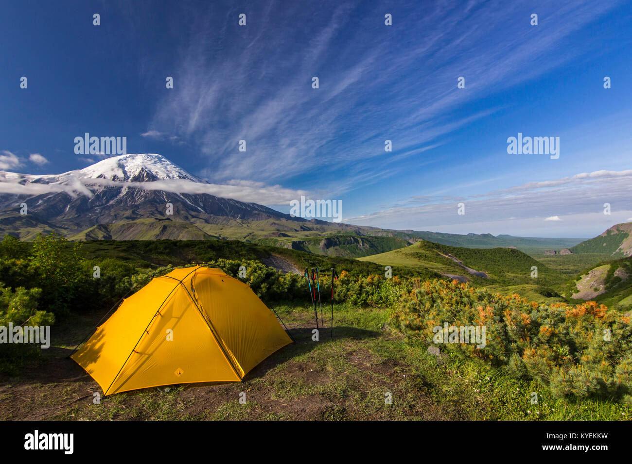 Tenda giallo su verde campo nei pressi di vulcani attivi della Kamchatka con le nuvole in cielo al tramonto Foto Stock