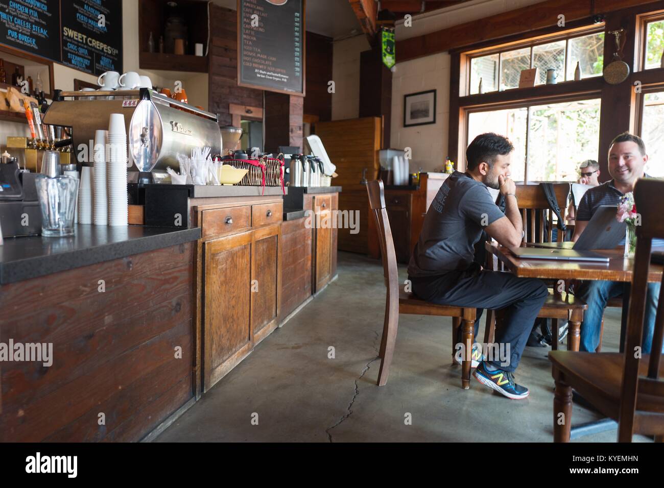 Due uomini seduti ad un tavolo durante una riunione, uno con un laptop, presso la latteria, un ristorante popolare con tecnologia di elementi di avvio e venture capitalist investitori nel sud del mercato (SOMA) quartiere di San Francisco, California, 13 ottobre 2017. SoMa è noto per avere una delle più alte concentrazioni di aziende di tecnologia e di startup di qualsiasi altra regione del mondo. () Foto Stock