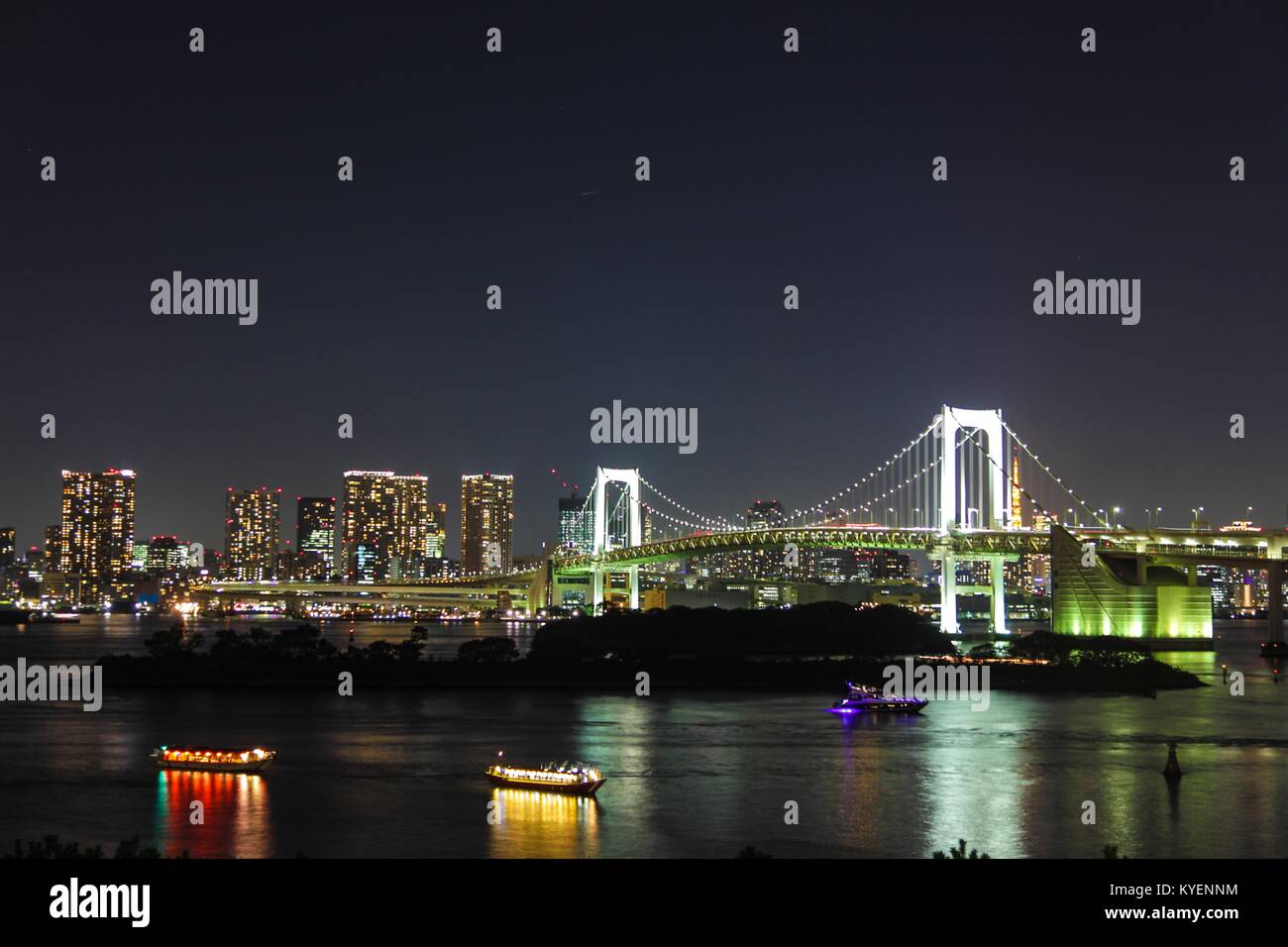 Vista notturna di Urban Skyline, compreso il Rainbow Bridge e Odaiba, un quartiere di shopping su un'isola artificiale nella Baia di Tokyo, Tokyo, Giappone, con barche yakatabune visibile, Ottobre 26, 2017. () Foto Stock