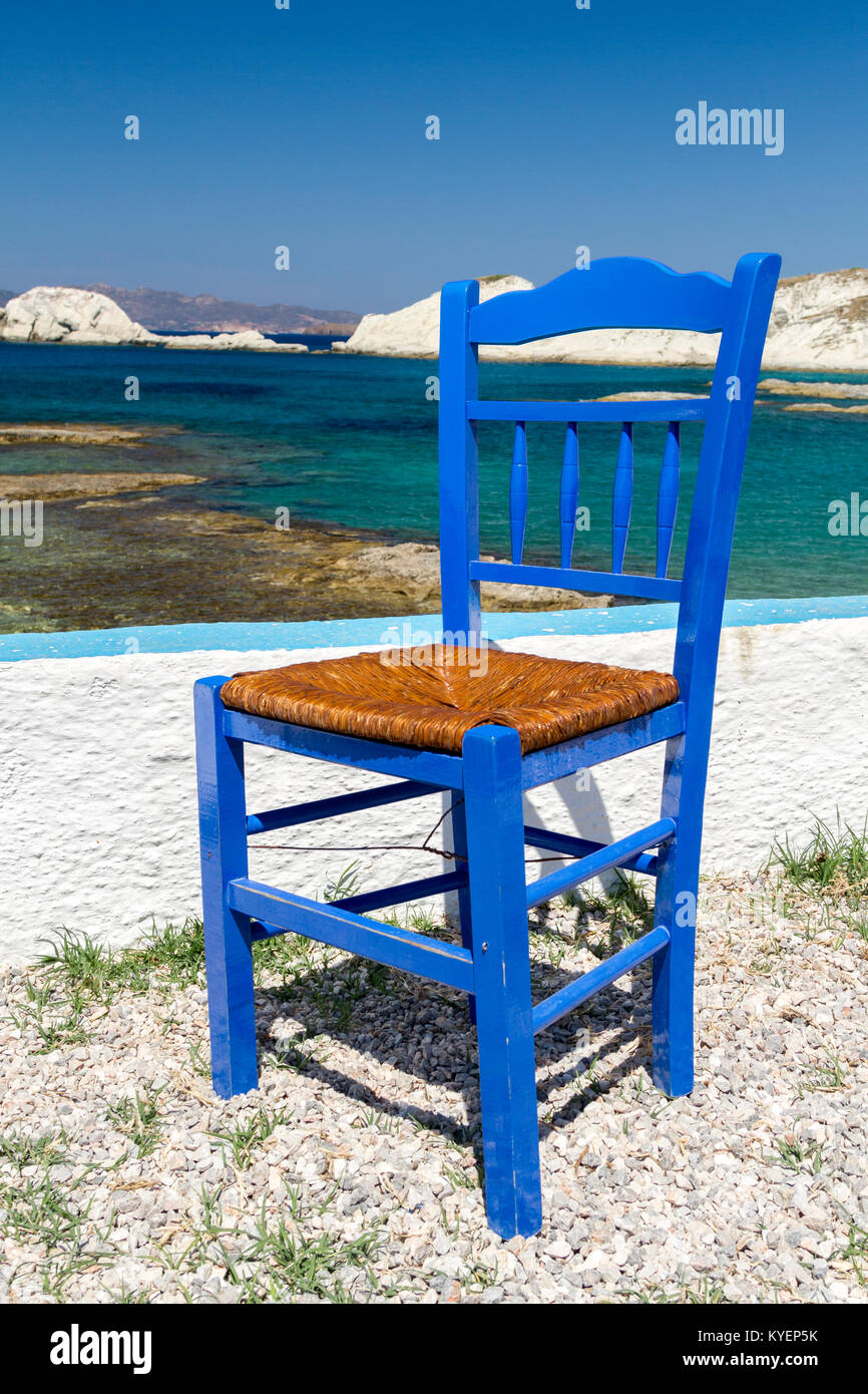 Tradizionale blu sedia dipinta dal mare con una vista delle Cicladi in background Foto Stock