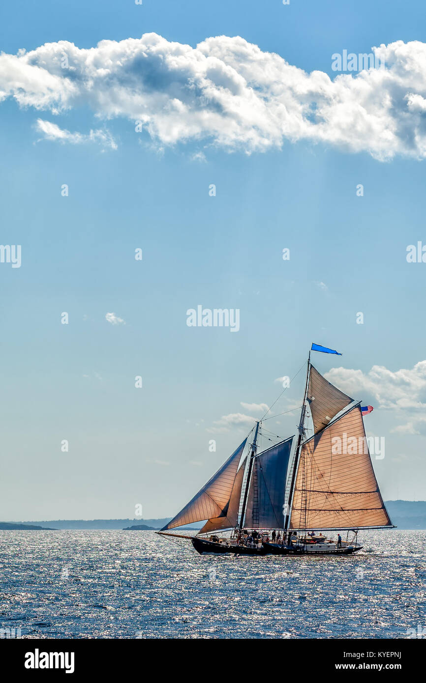 Vintage goletta a vela yacht al largo delle coste del Maine sotto le nuvole alte e cielo blu. Copia dello spazio. Verticale. Foto Stock