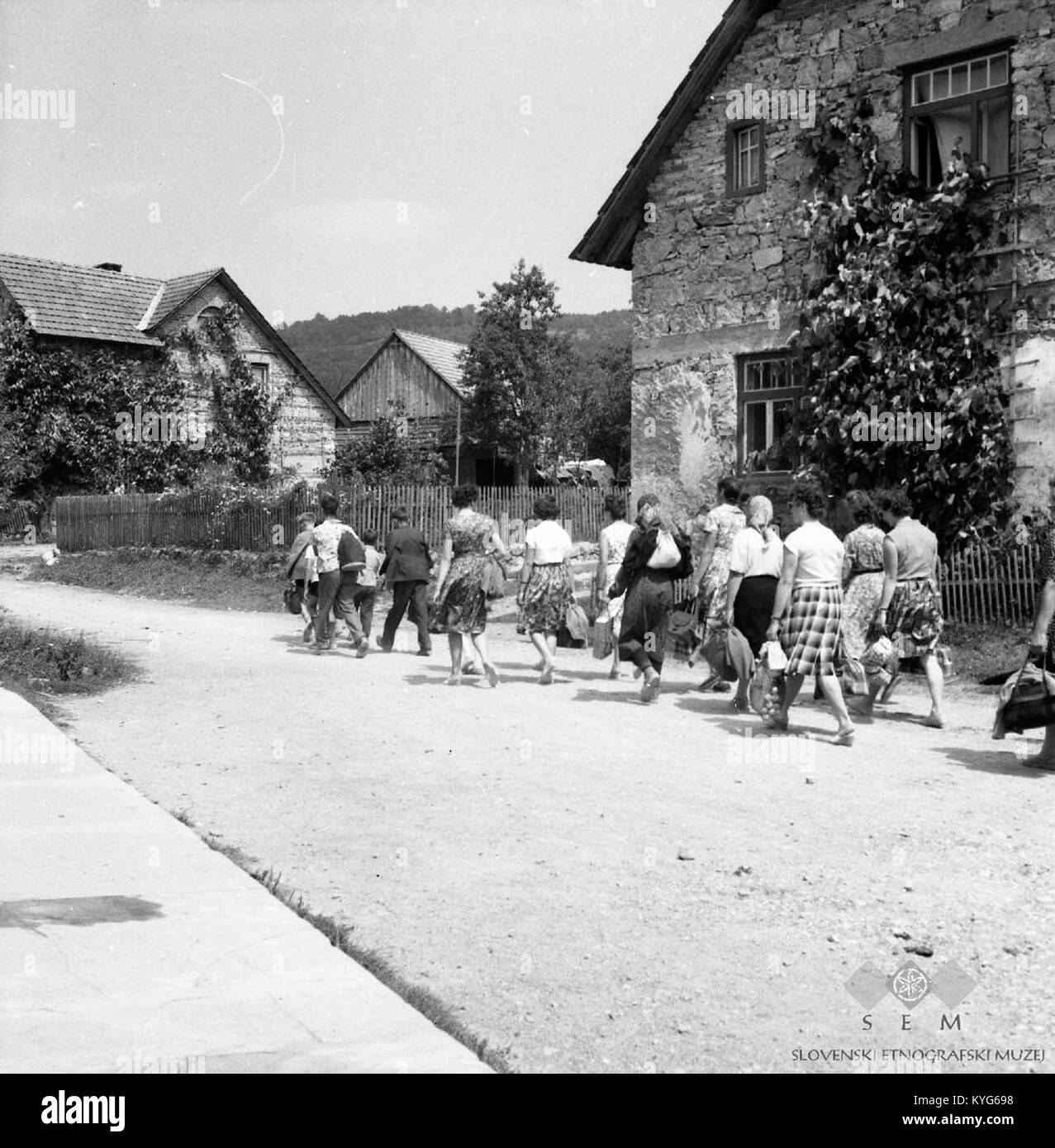 Fotografia della processione del 1962 contro la peste a Novi Stifti, Vrhnika, Slovenia, che mostra gli abitanti del villaggio, simboli religiosi, le strade e la solidarietà della comunità Foto Stock