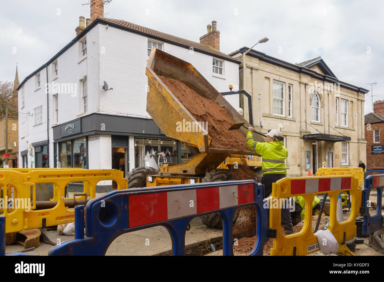 I lavoratori che indossa giacche ad alta visibilità con dumper macchina durante i lavori stradali a Oakham Rutland England Regno Unito Foto Stock