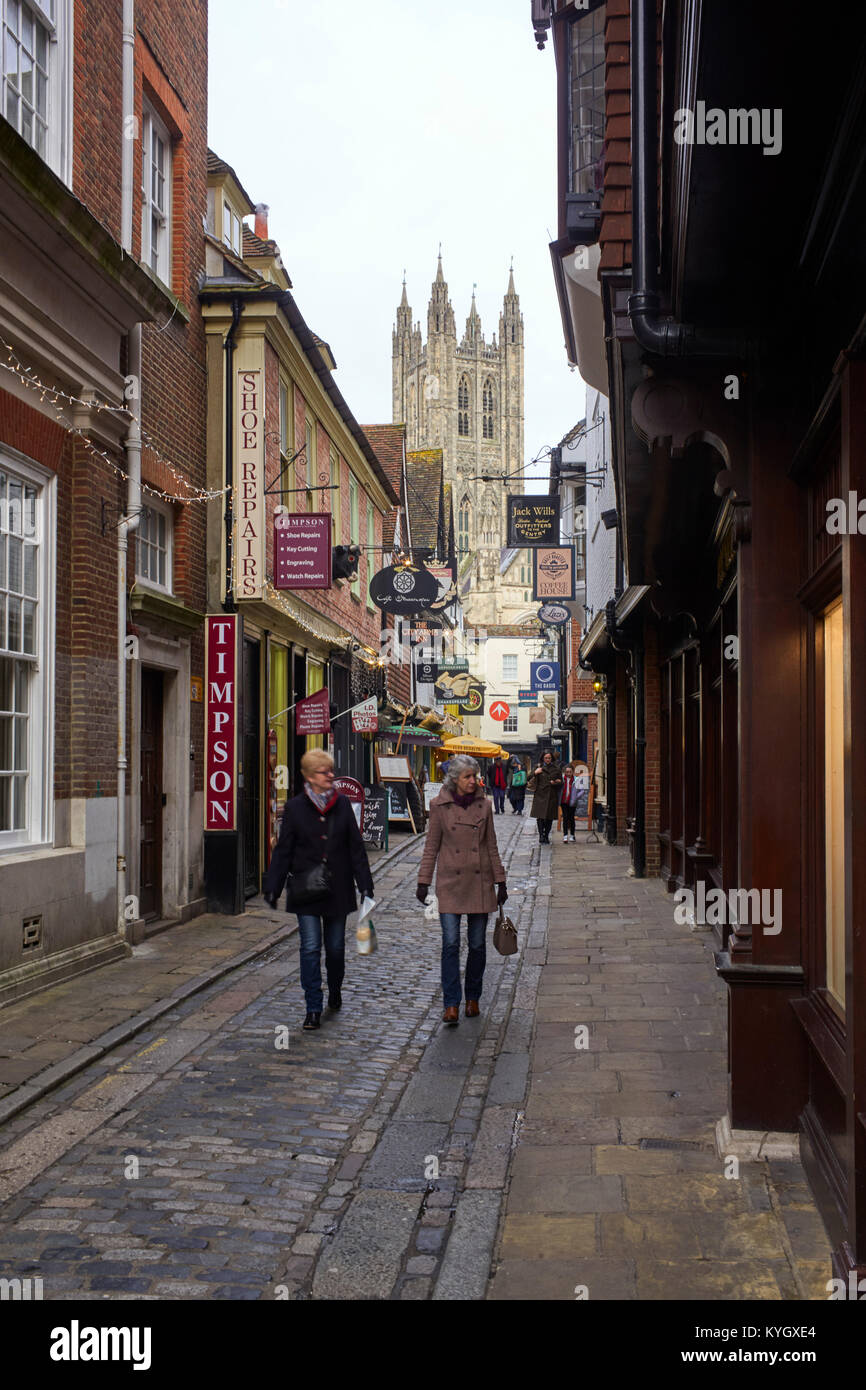 Le strette Mercery Lane a Canterbury con molti appese insegne dei negozi e la cattedrale in background Foto Stock