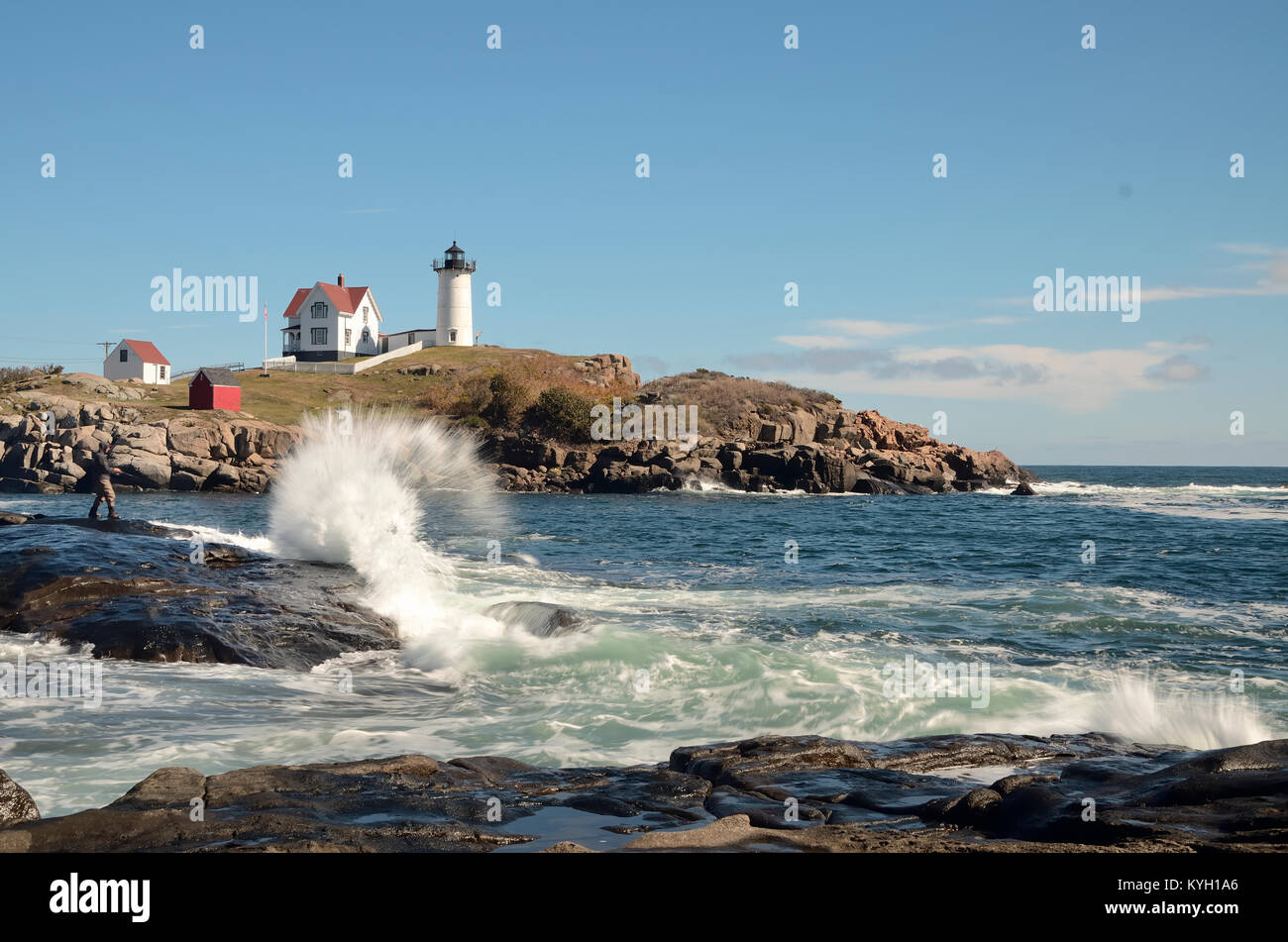 Onde si infrangono nella parte anteriore del faro Nubble, Cape Neddick Maine. Blue sky. Foto Stock