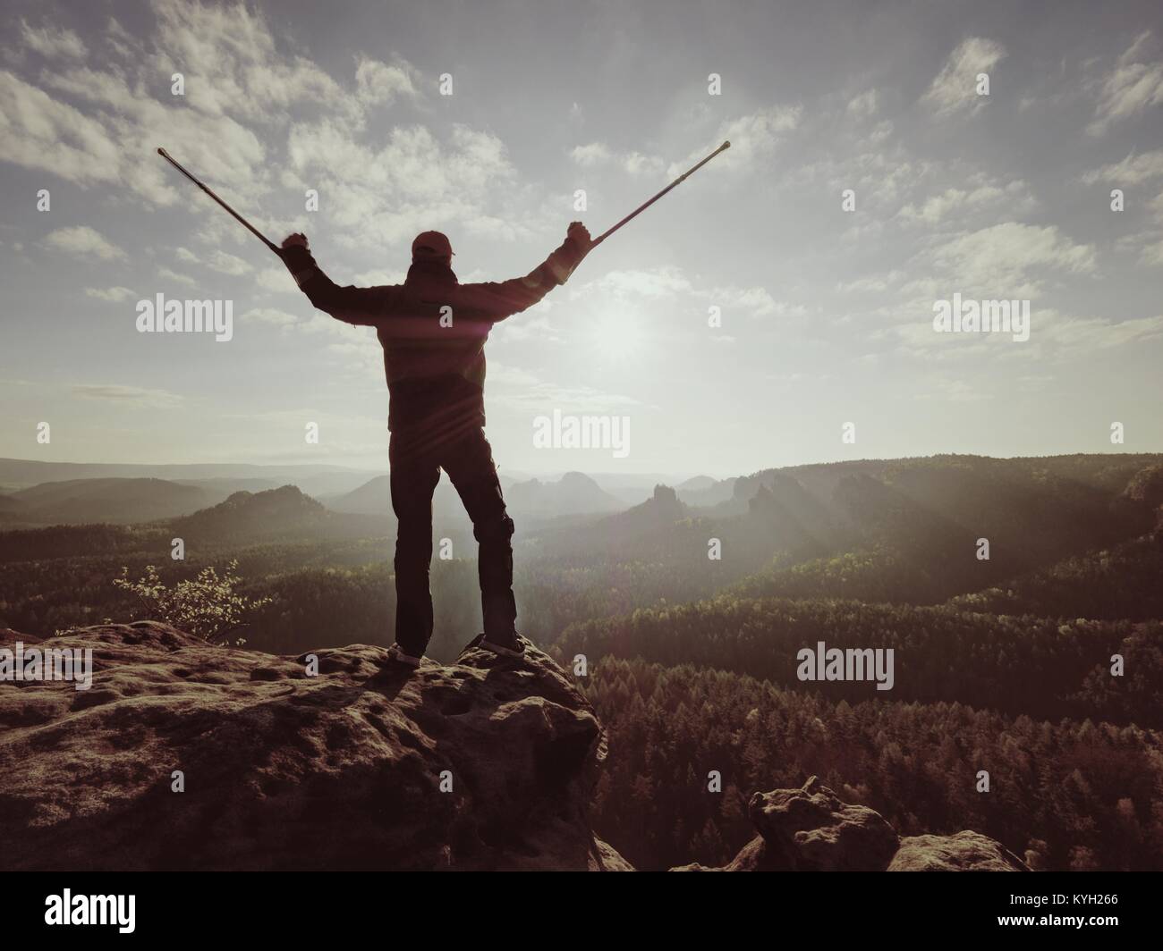 Escursionista con la medicina stampella sopra la testa raggiunto traguardo personale. Gamba rotta fissata in un immobilizzatore profonda valle misty bellow silhouette di un uomo con la mano Foto Stock