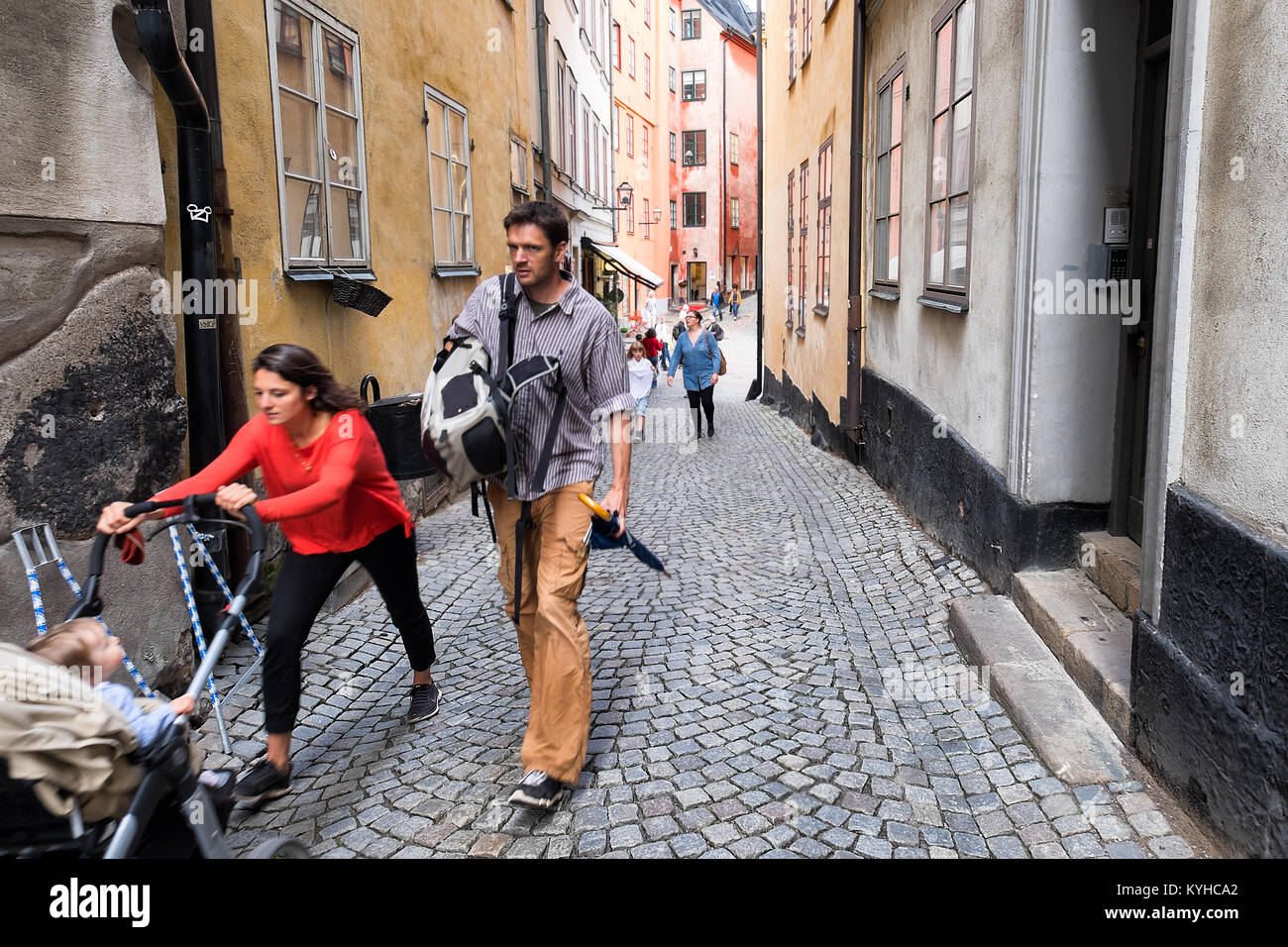 Stoccolma Svezia genitori spingere un passeggino in salita su una ripida strada acciottolata Gamla Stan, o Città Vecchia, il centro storico della città. Foto Stock