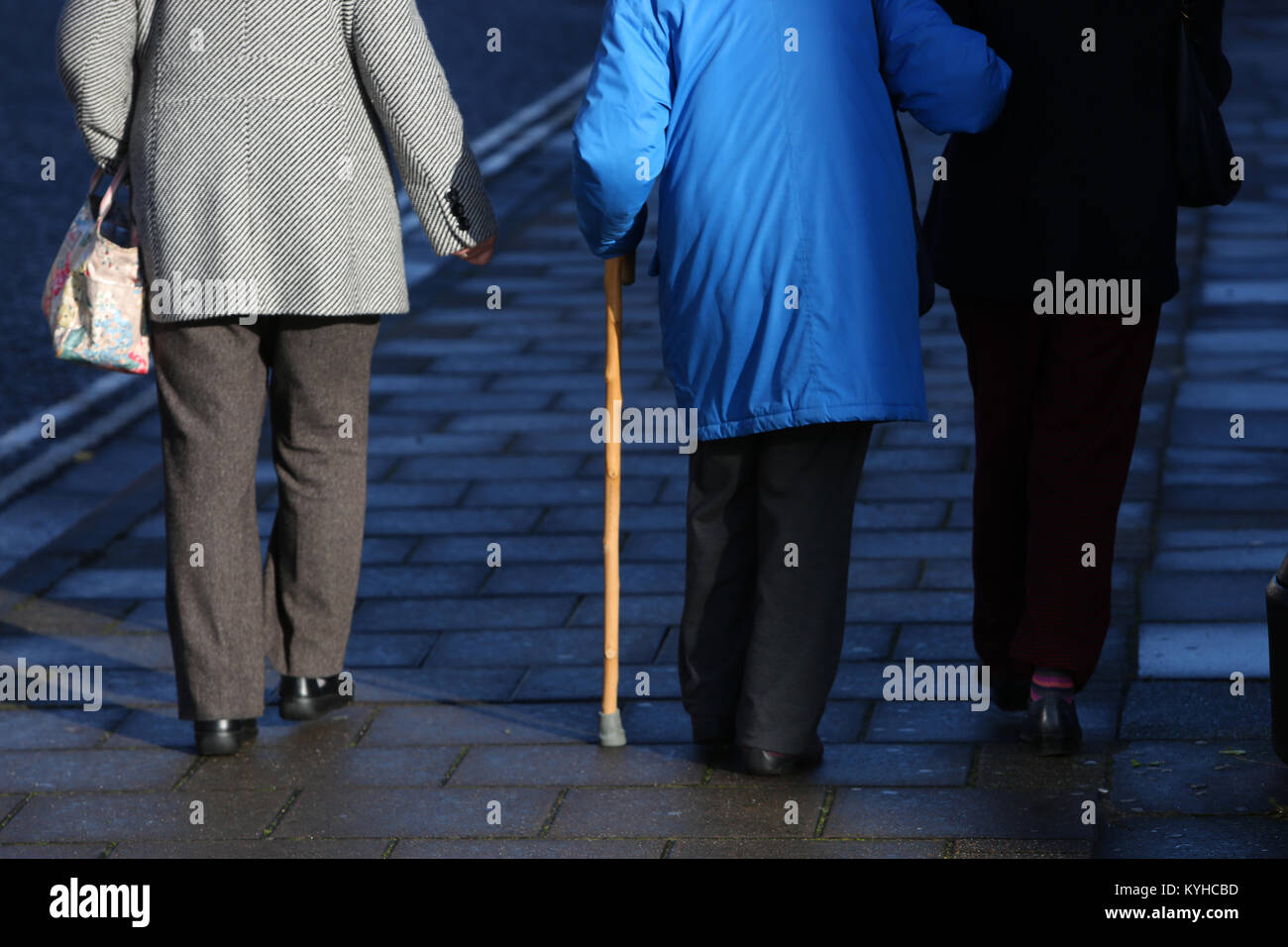 Tre donne anziane nella foto a piedi lungo la strada nel Sussex, Regno Unito. Foto Stock