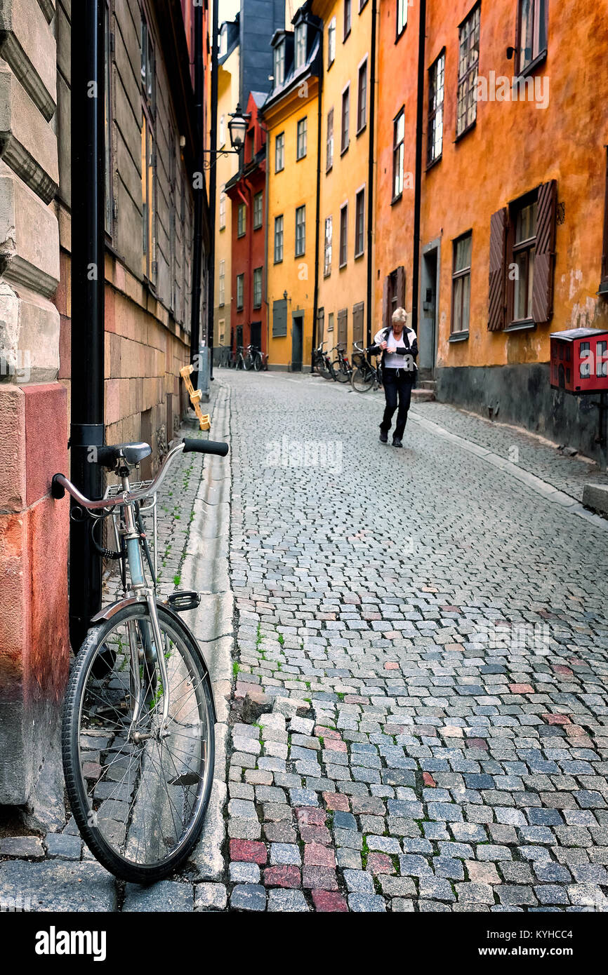 Stoccolma Svezia bella colorata in ciottoli street nel centro storico quartiere Gamla Stan. Vista è alla ricerca in salita. Foto Stock