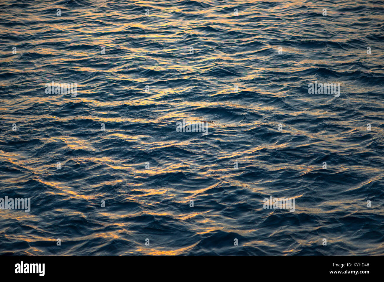 Le increspature sulla superficie di un mare calmo al tramonto nella luce dorata, all isola di Satonda, Indonesia. Foto Stock