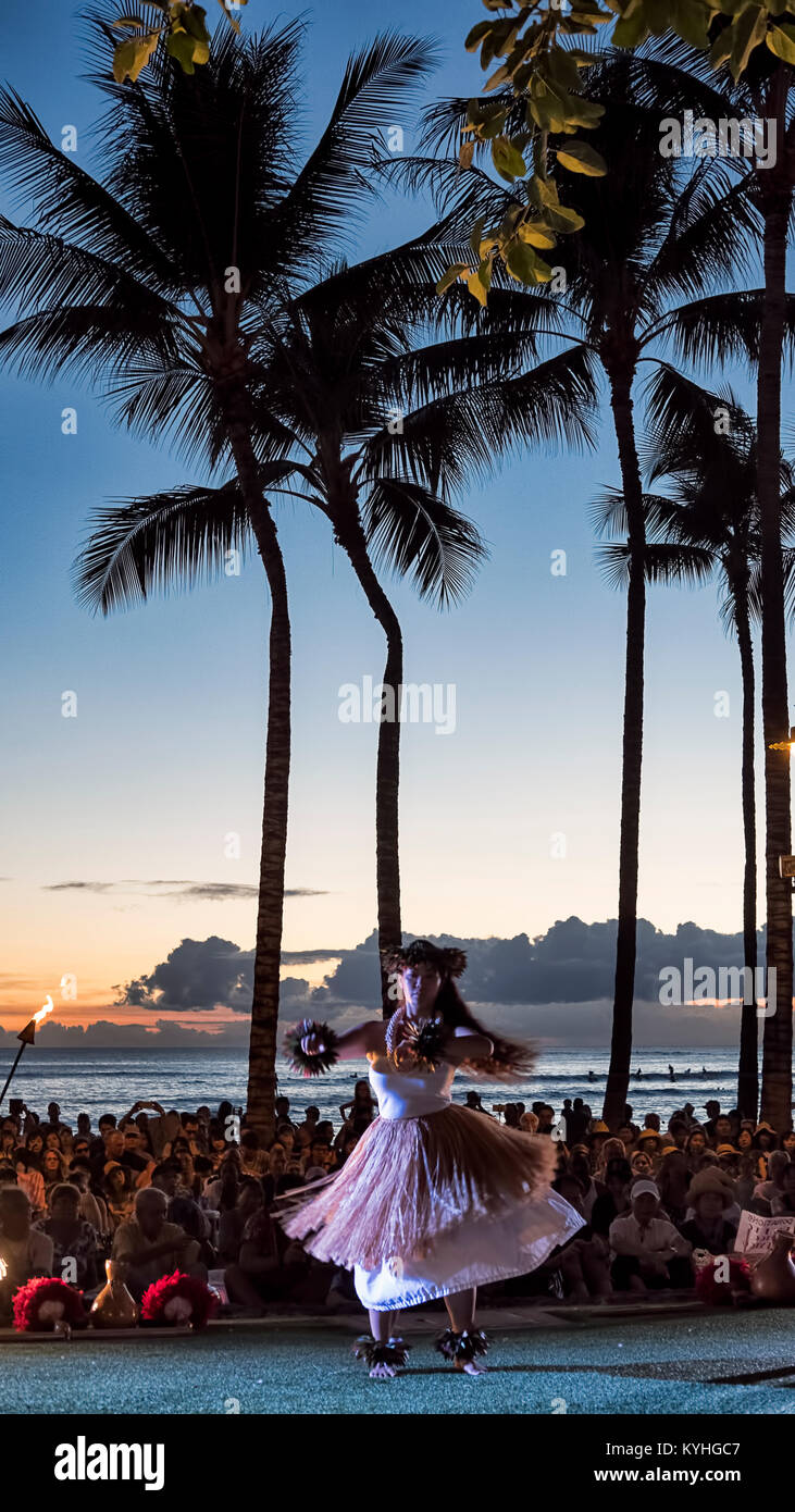 La spiaggia di Waikiki, Honolulu Oahu Island, Hawaii - 27 Settembre 2017: femmina attraente ballerina di hula su un piccolo palcoscenico, a Waikiki beach, al tramonto Foto Stock