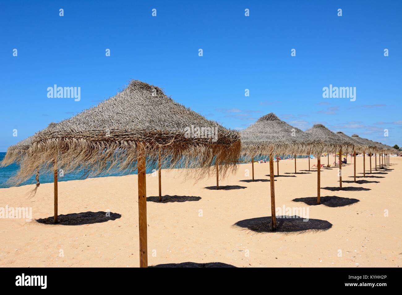 Righe di rafia ombrelloni sulla spiaggia con l'Oceano Atlantico verso la  parte posteriore, Vilamoura, Algarve, Portogallo, dell'Europa Foto stock -  Alamy