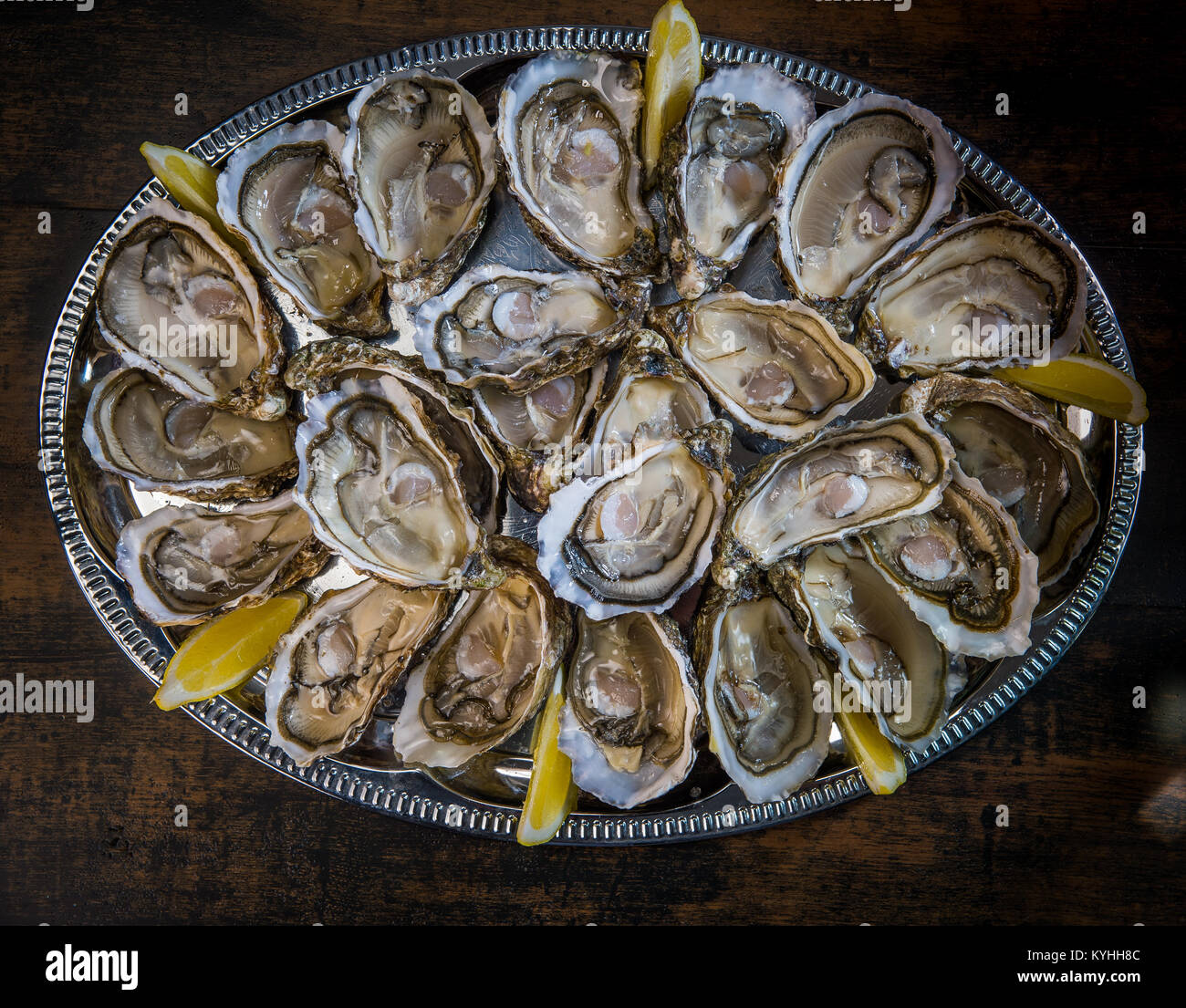 Ostriche fresche incavature fino al limone sul tavolo, Francia Foto Stock