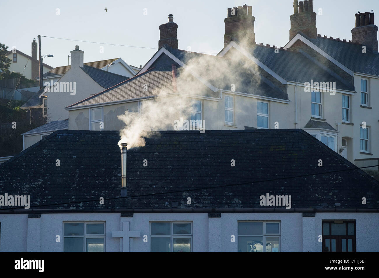 Polzeath - Fumo da un camino in metallo su una casa in città Polzeath in Cornovaglia. Foto Stock