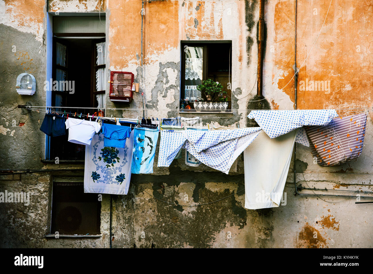 Vestiti appesi in alcune linee di abbigliamento all'aperto in un antico edificio nel centro storico di Cagliari, Sardegna, Italia Foto Stock