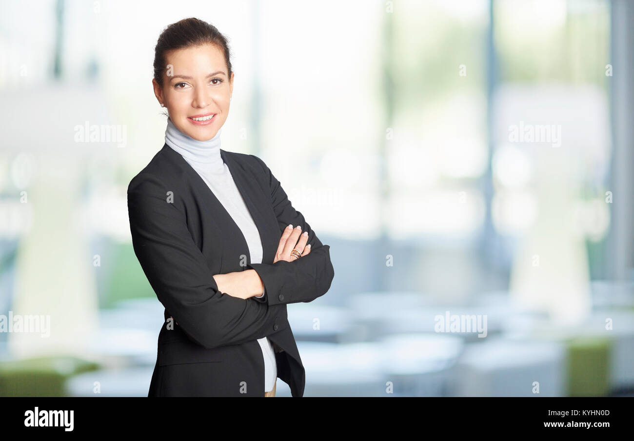 Un sorridente executive advisor finanziario imprenditrice in piedi con le braccia incrociate all'ufficio. Foto Stock