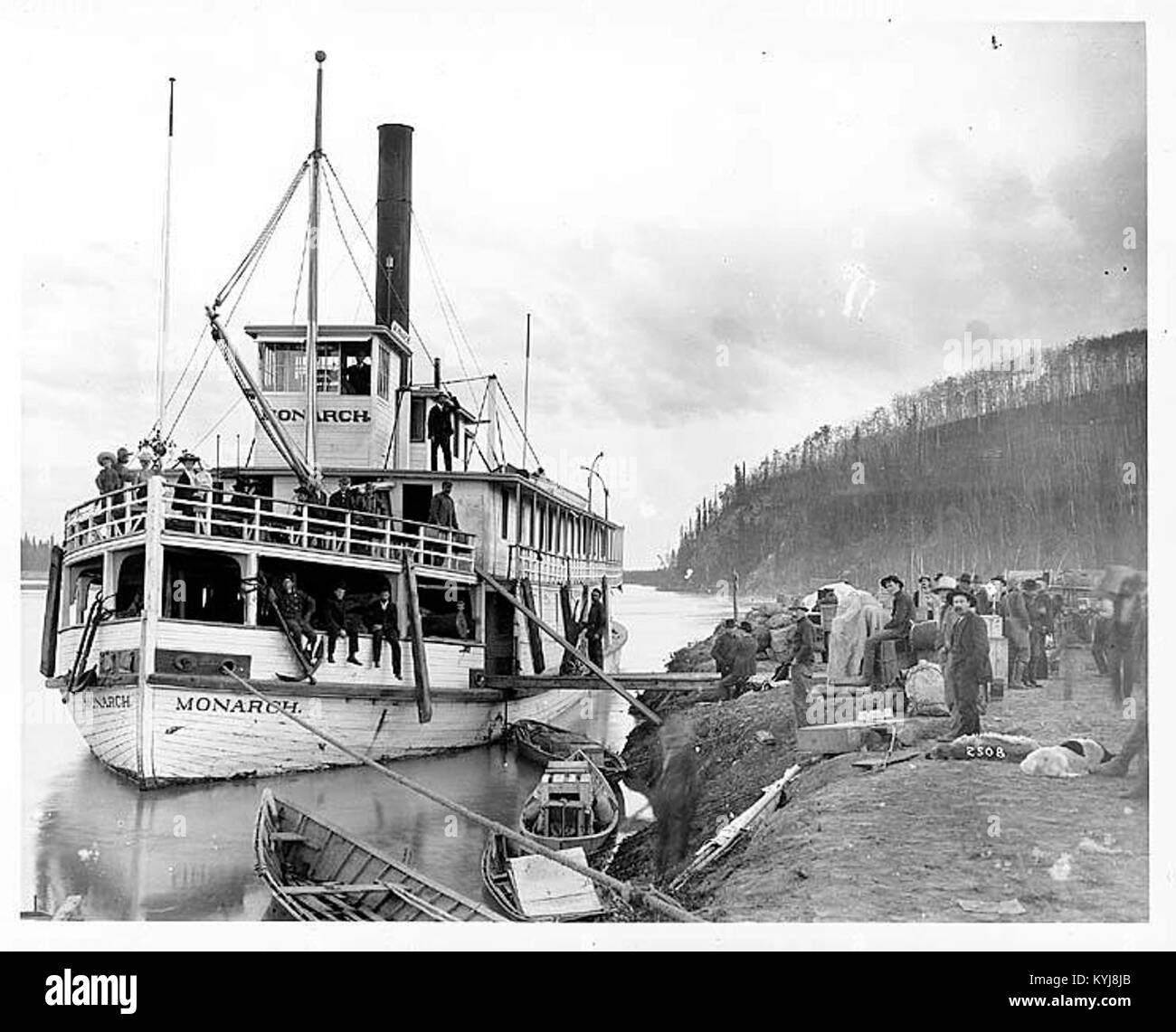 Il MONARCA era un battello a vapore che operava in Alaska intorno al 1904, raffigurato qui con i passeggeri in uno sbarco sul fiume. L'immagine cattura il ruolo della nave nel trasporto di persone e merci lungo i fiumi dell'Alaska. Foto Stock