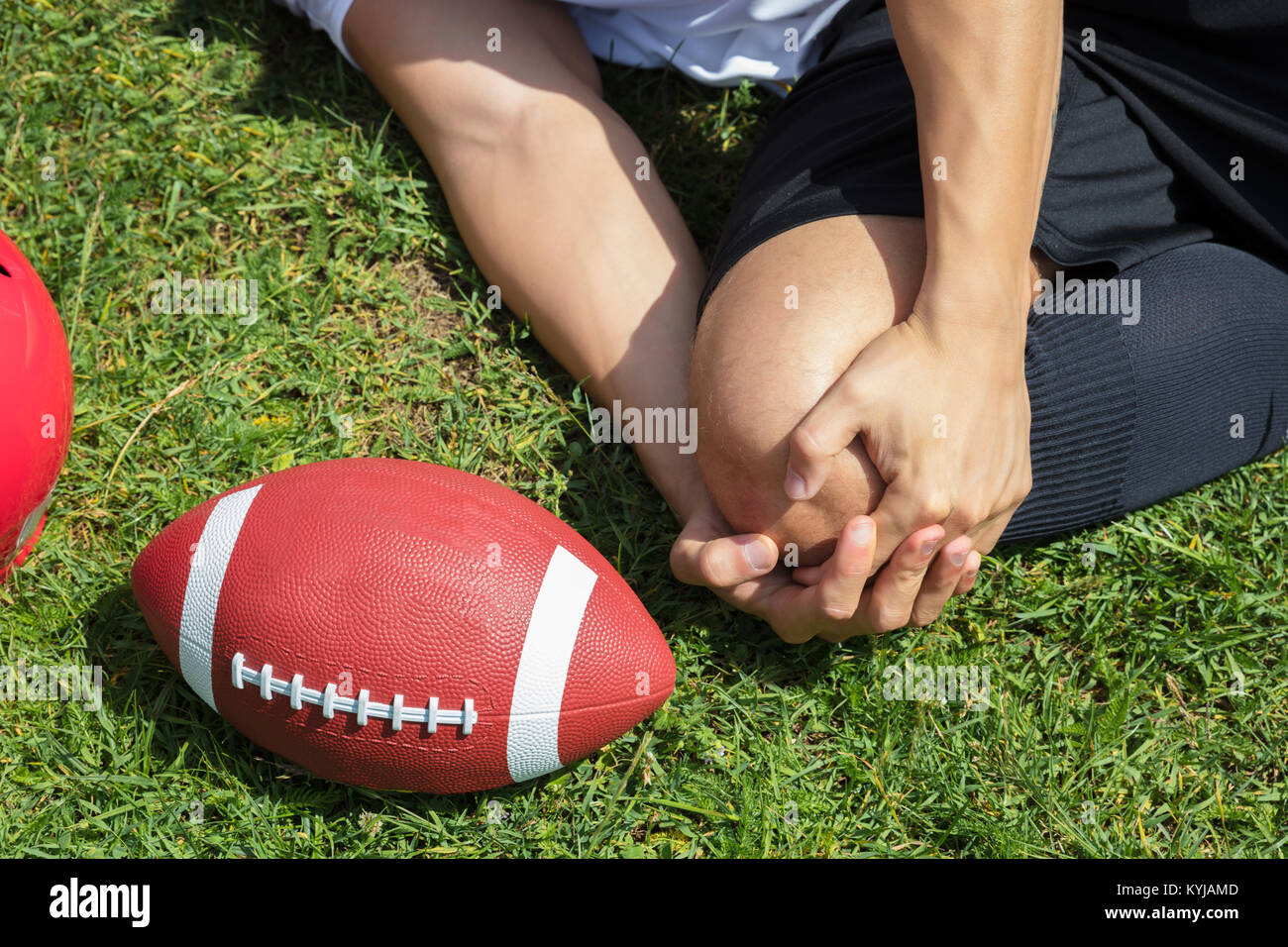 Close-up dei maschi di giocatore di rugby che soffrono di lesioni del ginocchio giacente sul campo Foto Stock