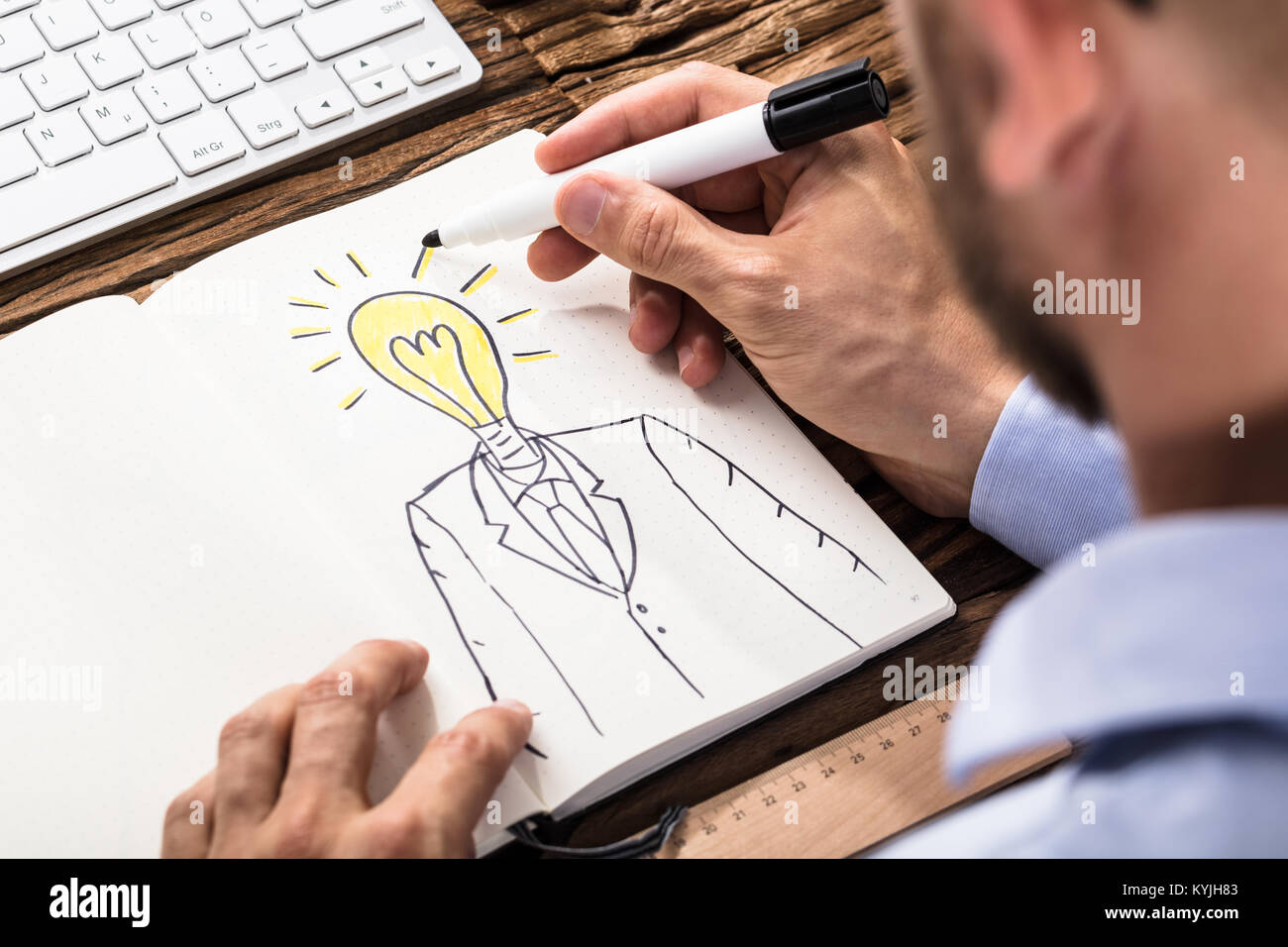 Close-up di imprenditore il disegno di una persona con la luce accesa la testa della lampadina sul notebook Foto Stock
