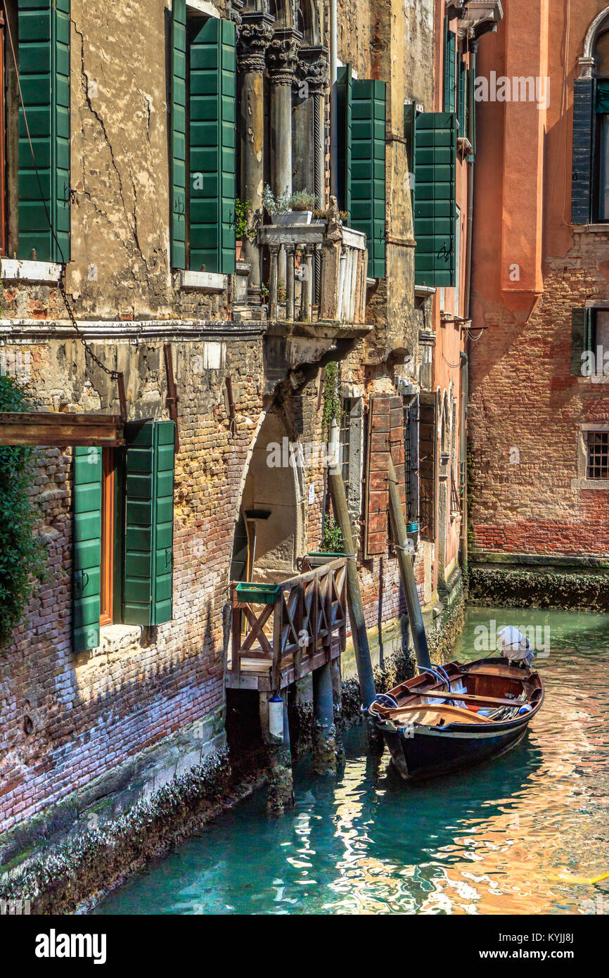 Una barca ormeggiata all'esterno di una casa su un tranquillo tratto residenziale di canale, Venezia, Italia. Aprile 2017. Foto Stock