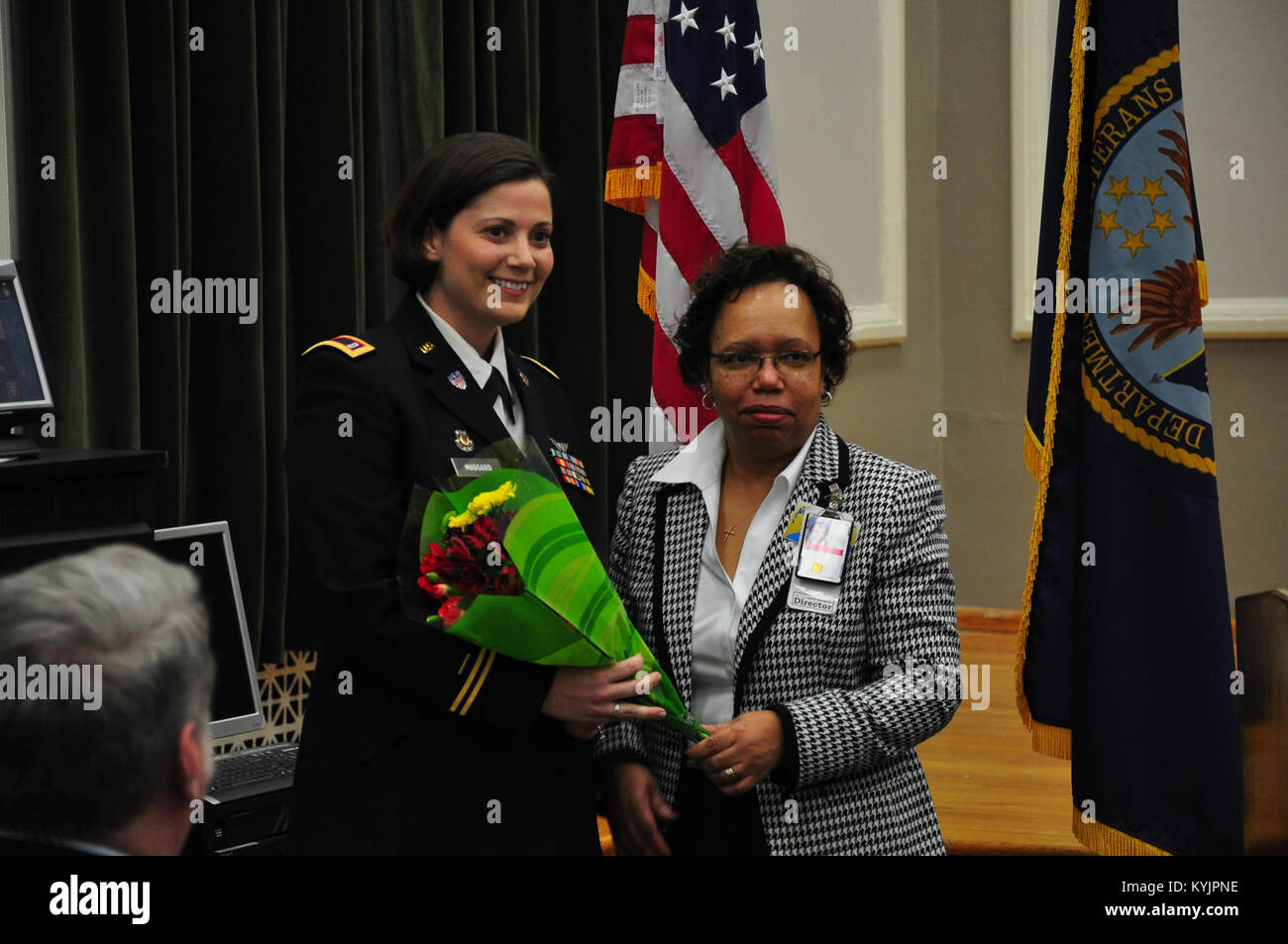 Il direttore di Lexington, KY. Veterans Affairs Medical Center, Emma Metcalf presenta fiori come un segno di apprezzamento al Chief Warrant Officer due Jennifer Maggard dal Kentucky Guardia Nazionale. Maggard fu ospite ad una donna storia mese Celebrazione in onore di donne veterani in Lexington Mar. 26. (U.S. Esercito nazionale Guard foto di Capt. Stephen Martin) Foto Stock