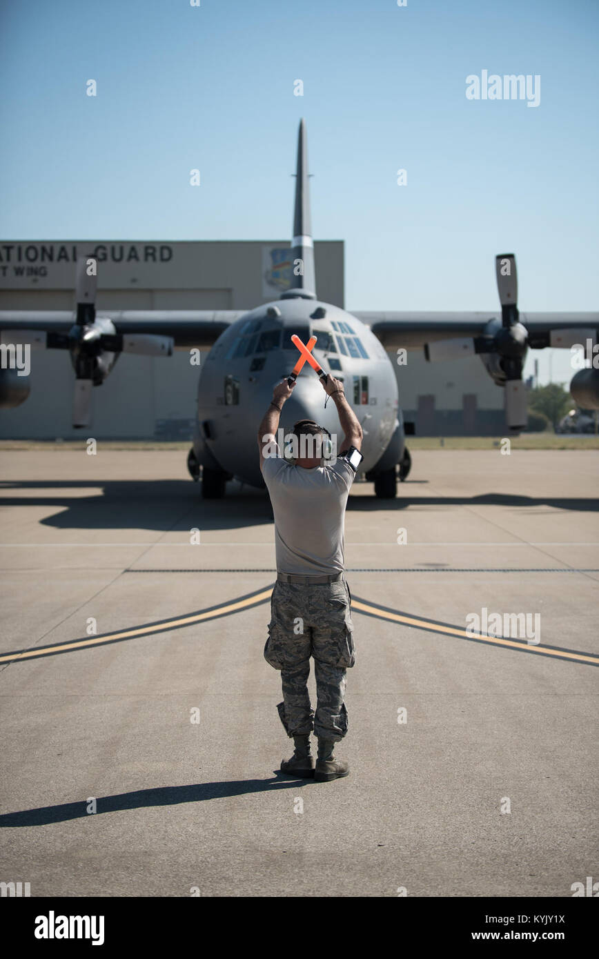Senior Airman Paolo Proctor II, un capo equipaggio nel Kentucky Air National Guard la 123ª Manutenzione aeromobili squadrone, esegue il marshalling di un C-130 Hercules aeromobile nel proprio posto di parcheggio al Kentucky Air National Guard Base in Louisville, KY. sett. 17, 2015. Il velivolo ha appena completato una formazione locale sortie e portava una delegazione di deputati di Gibuti militare, come parte della loro visita al 123Airlift Wing. Il Kentucky Guardia Nazionale e Gibuti sono ora partner nella Guardia Nazionale Ufficio di presidenza dello stato del programma di Partenariato per le coppie che un membro della guardia nazionale con le forze armate di un par Foto Stock