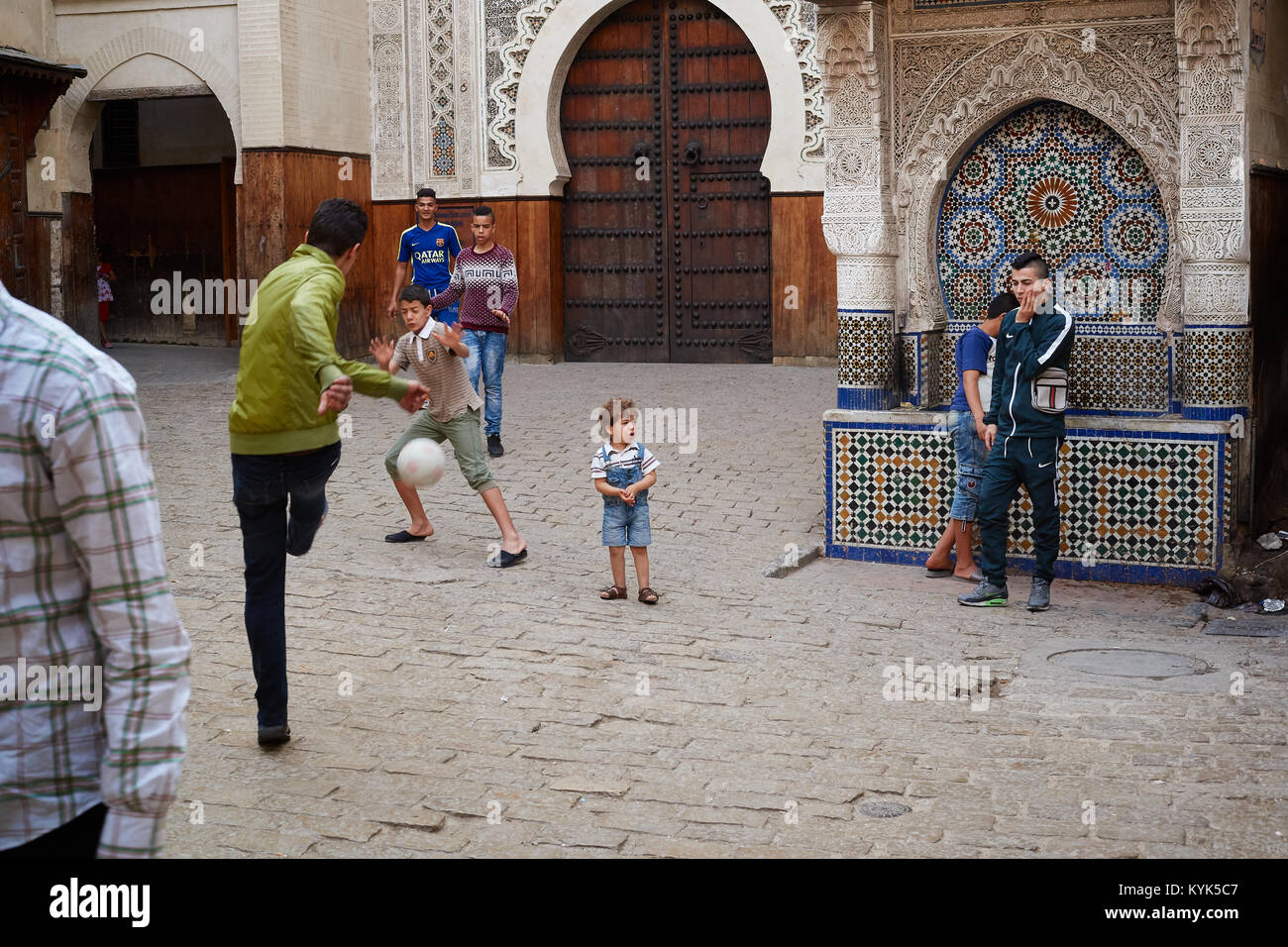 Moraccan ragazzi che giocano a calcio nella medina di Fez, Marocco Foto Stock