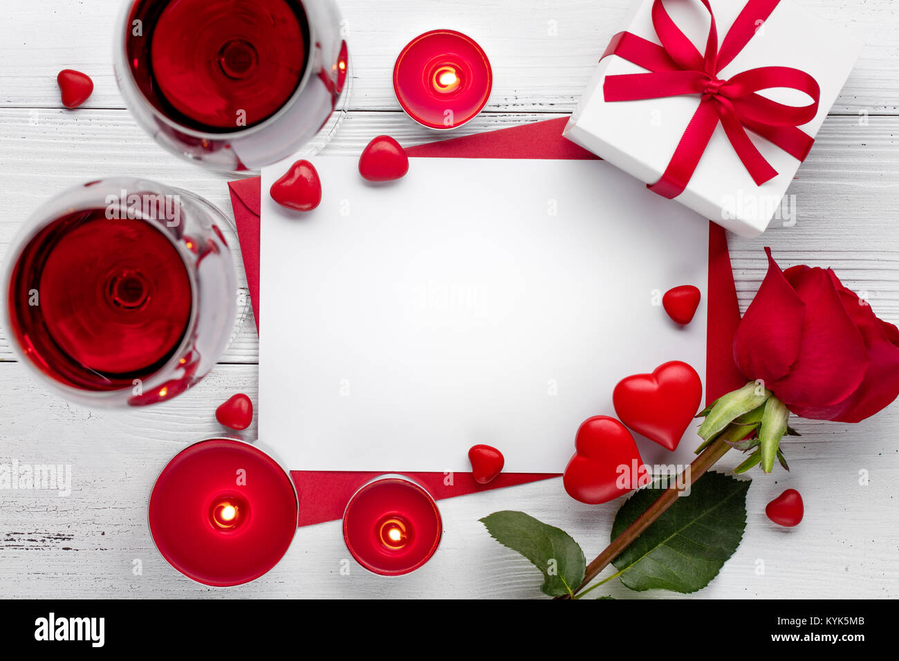 Il giorno di San Valentino festa con il vino rosso,candela che brucia e rose. Foto Stock
