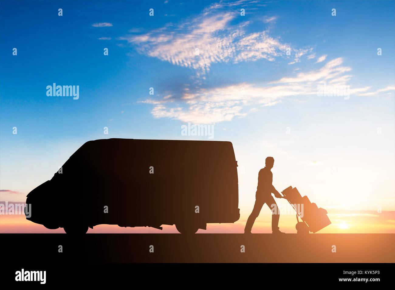 Silhouette di corriere per la consegna con scatole di cartone su carrello in prossimità del Van al tramonto Foto Stock