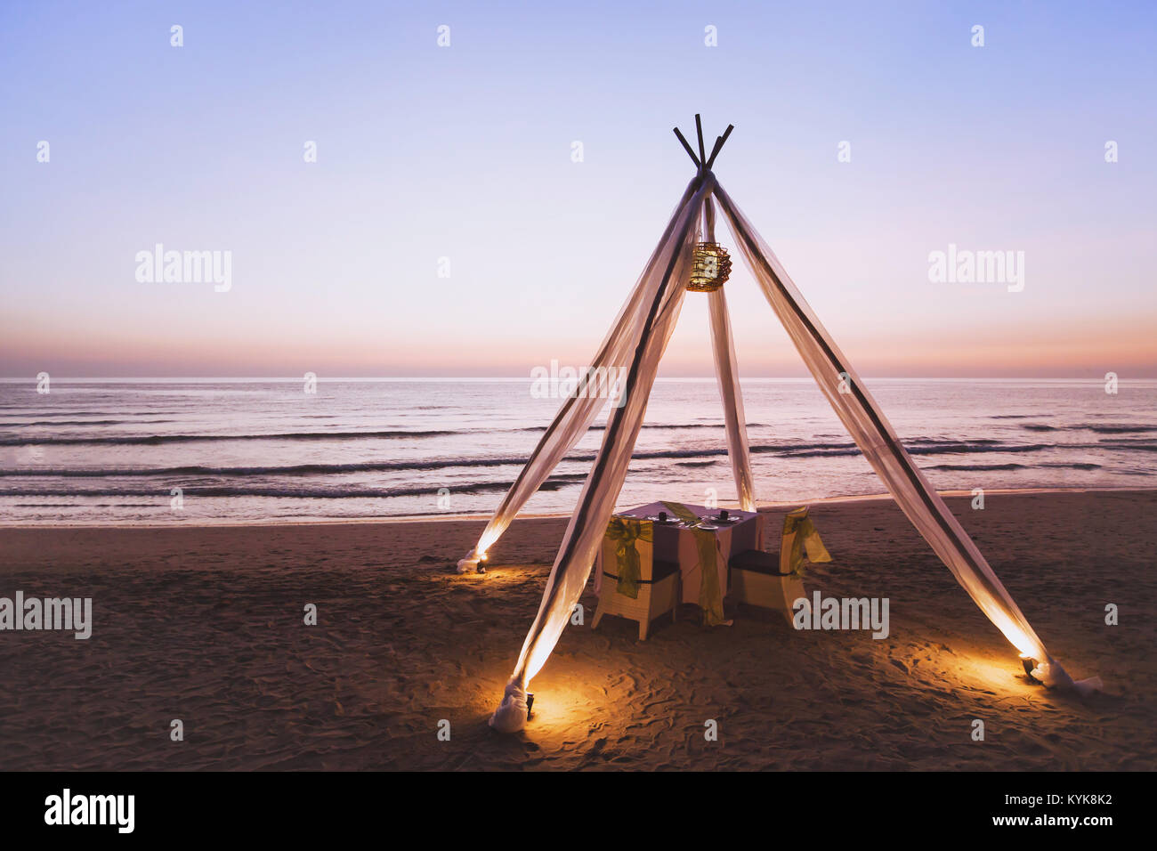 Luna di miele a cena per coppie in viaggio di nozze sulla spiaggia in un lussuoso albergo romantico e bel tavolo per due al tramonto Foto Stock