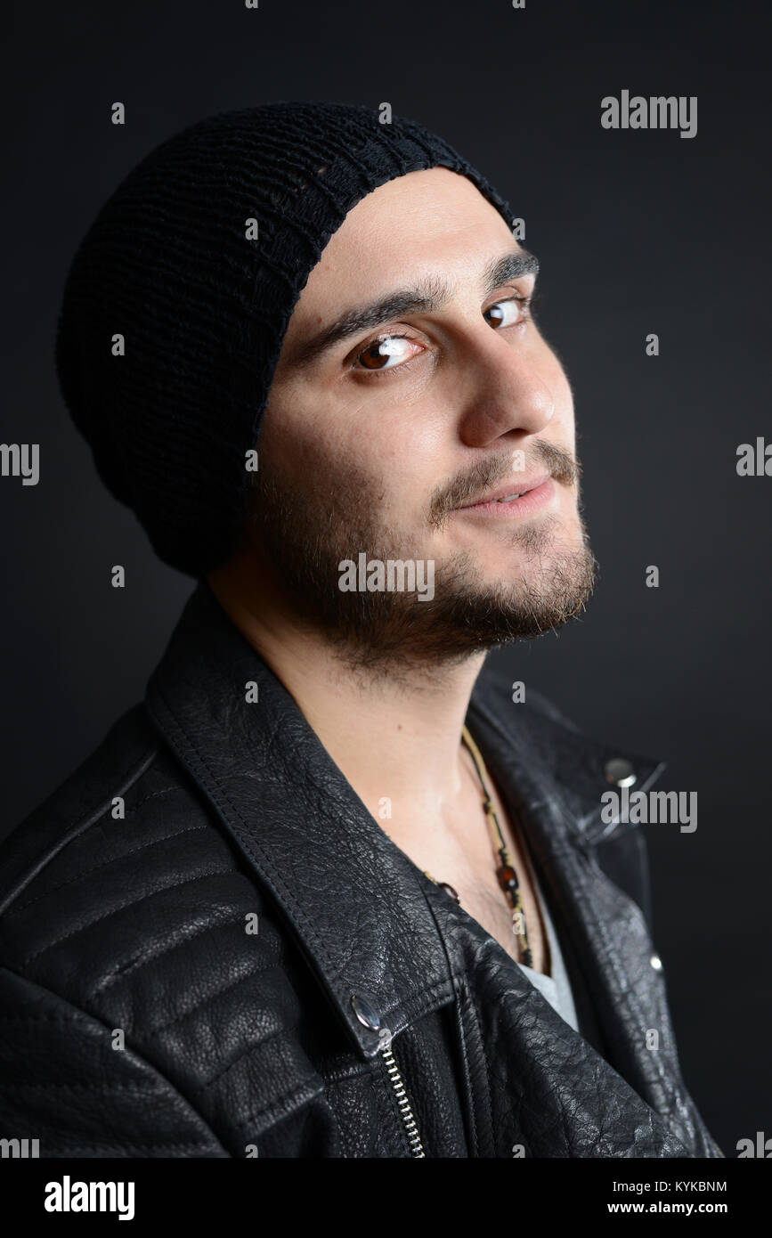 Il cantante rock ritratto, con giacca di pelle e un atteggiamento fresco su sfondo nero, studio shot Foto Stock