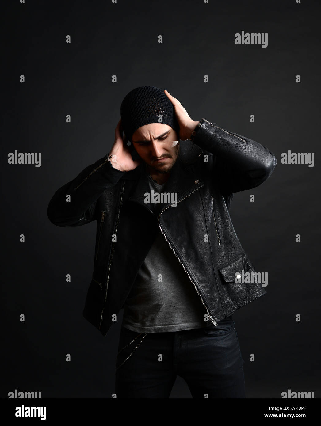 Il cantante rock ritratto, con giacca di pelle e un atteggiamento fresco su sfondo nero, studio shot Foto Stock