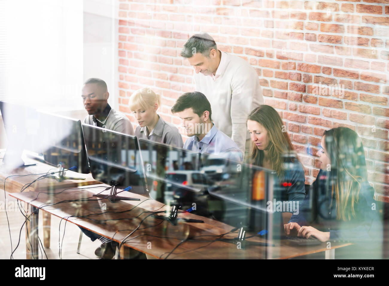 Il gruppo di cinque giovani studenti di sesso maschile con insegnante nella scuola di computer Classroom Foto Stock