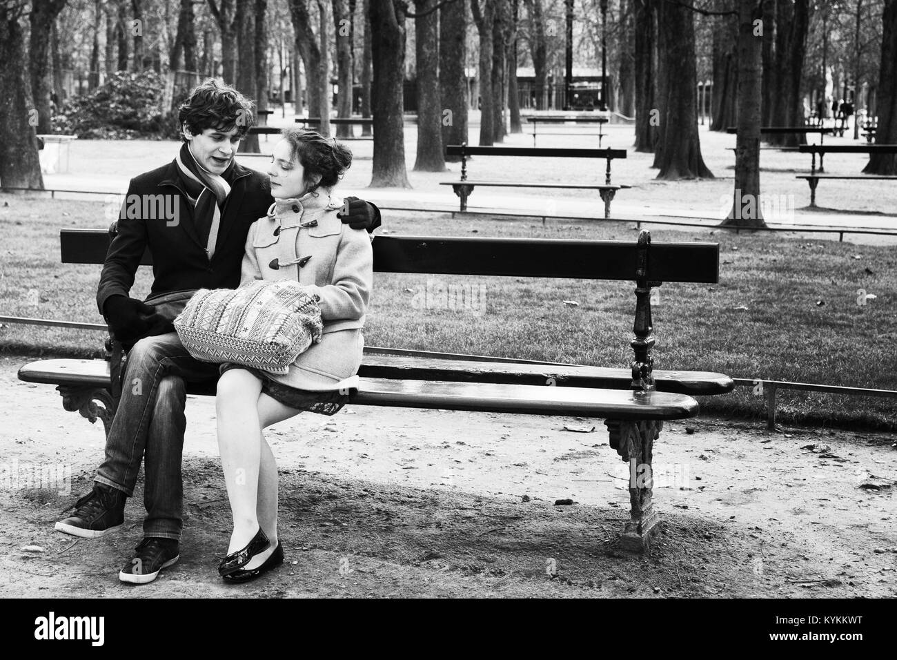 Parigi-gen. 4, 2014: non identificato un giovane seduto su una panchina nel parco all'Luxumbourg Giardini, molto popolare di destinazione romantica a Parigi. Nero e Foto Stock