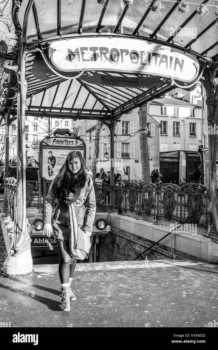 Parigi, Francia. Una donna bellissima all'ingresso al famoso art nouveau la stazione della metropolitana di al Abbesses a Montmartre. In bianco e nero Foto Stock