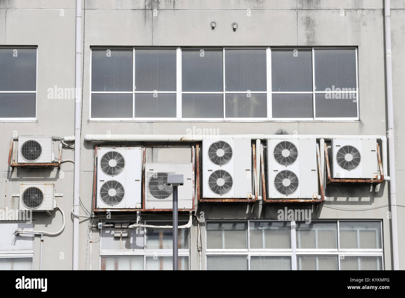 Condizionatori di aria sulla parete, tante arie del compressore sono appesi su una parete Foto Stock
