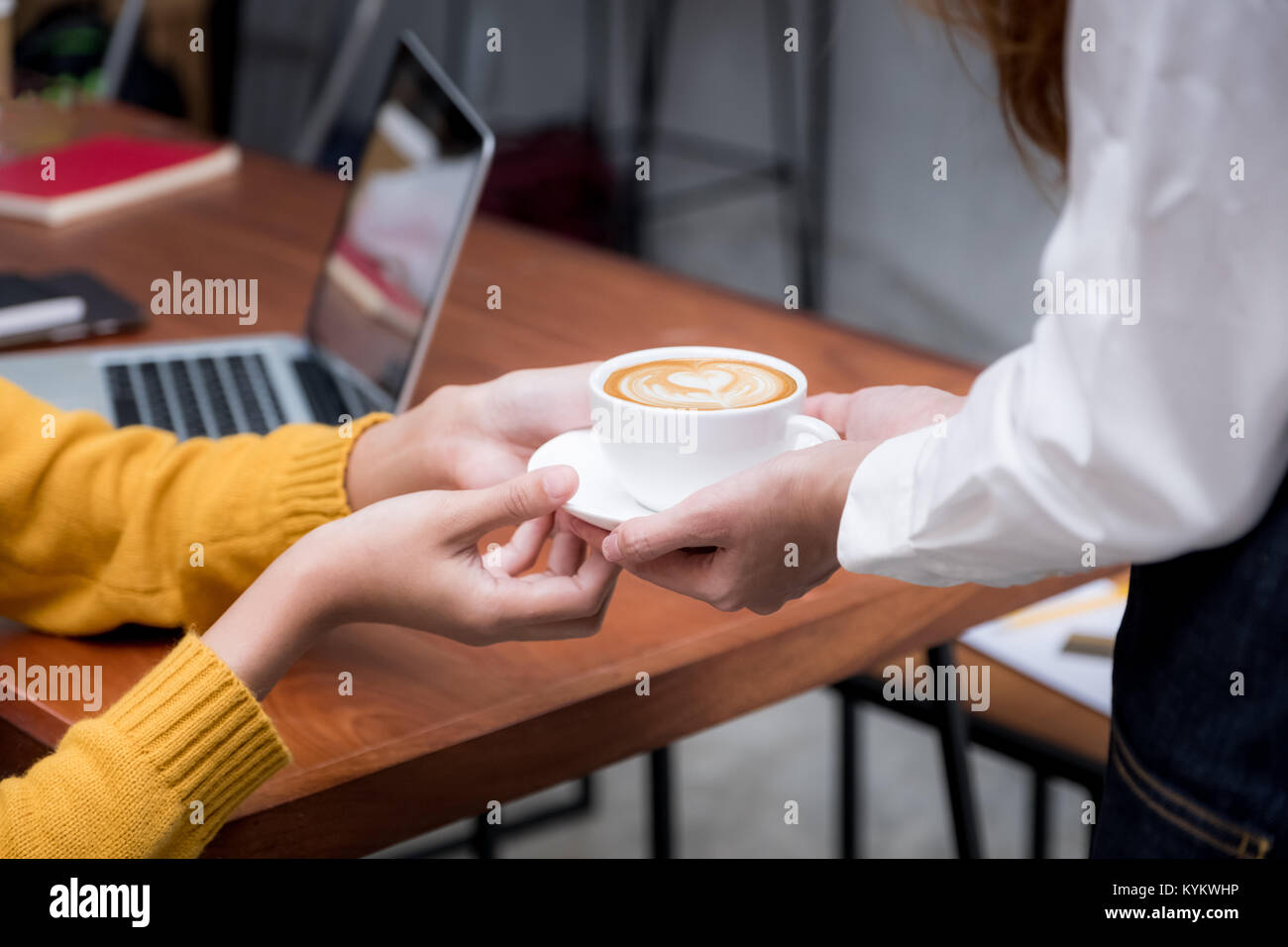 Donna asiatica barista azienda tazza da caffè servito al cliente al tavolo,Cafe Restaurant service concetto,proprietario small business concetto. Foto Stock