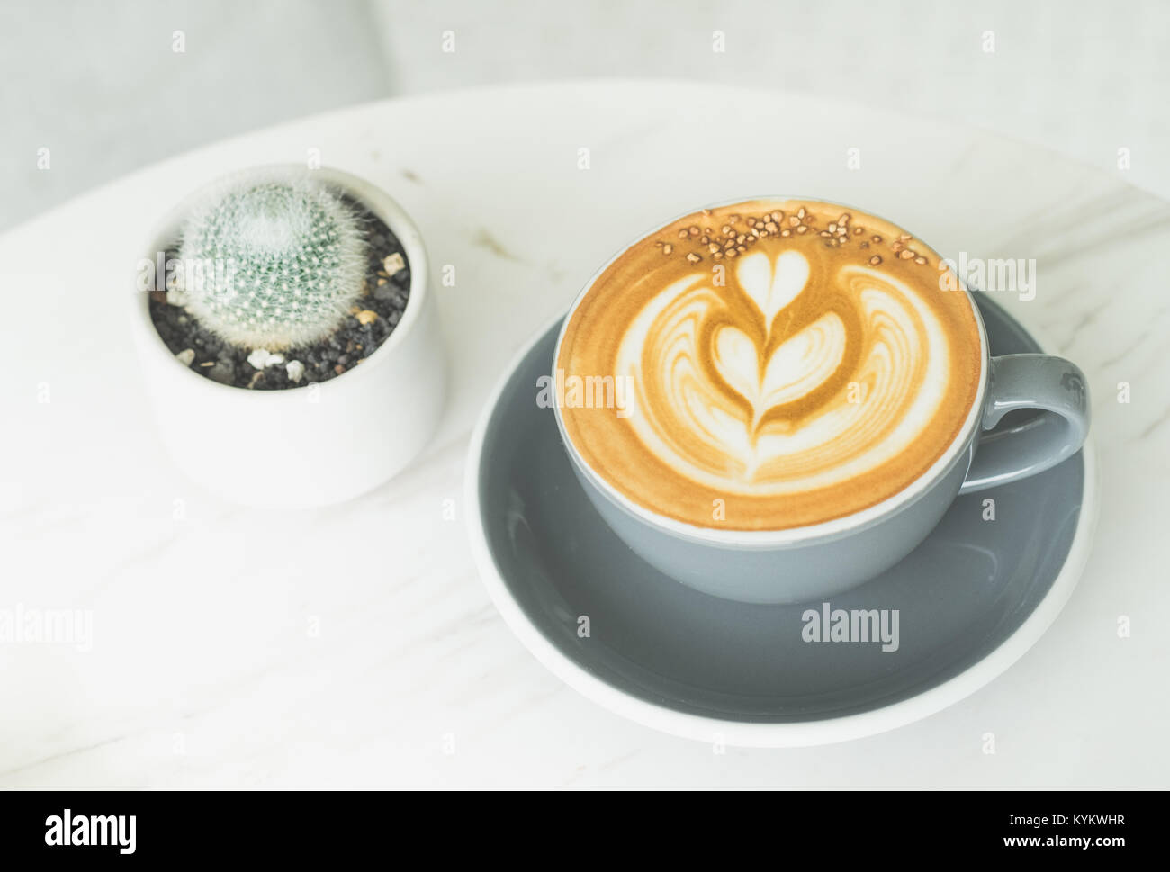 Cappuccino con tree latte art in blu tazza da caffè su marmo bianco tavola in vista prospettica in cafe,lo stile di vita moderno leisure. Foto Stock