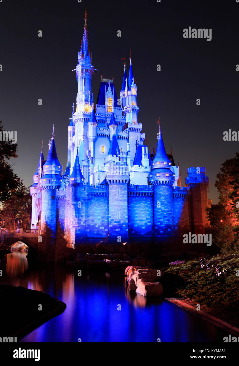 Il Castello di Cenerentola illuminata di notte in montagna con riflessi nel lago, Magic Kingdom, Florida Foto Stock